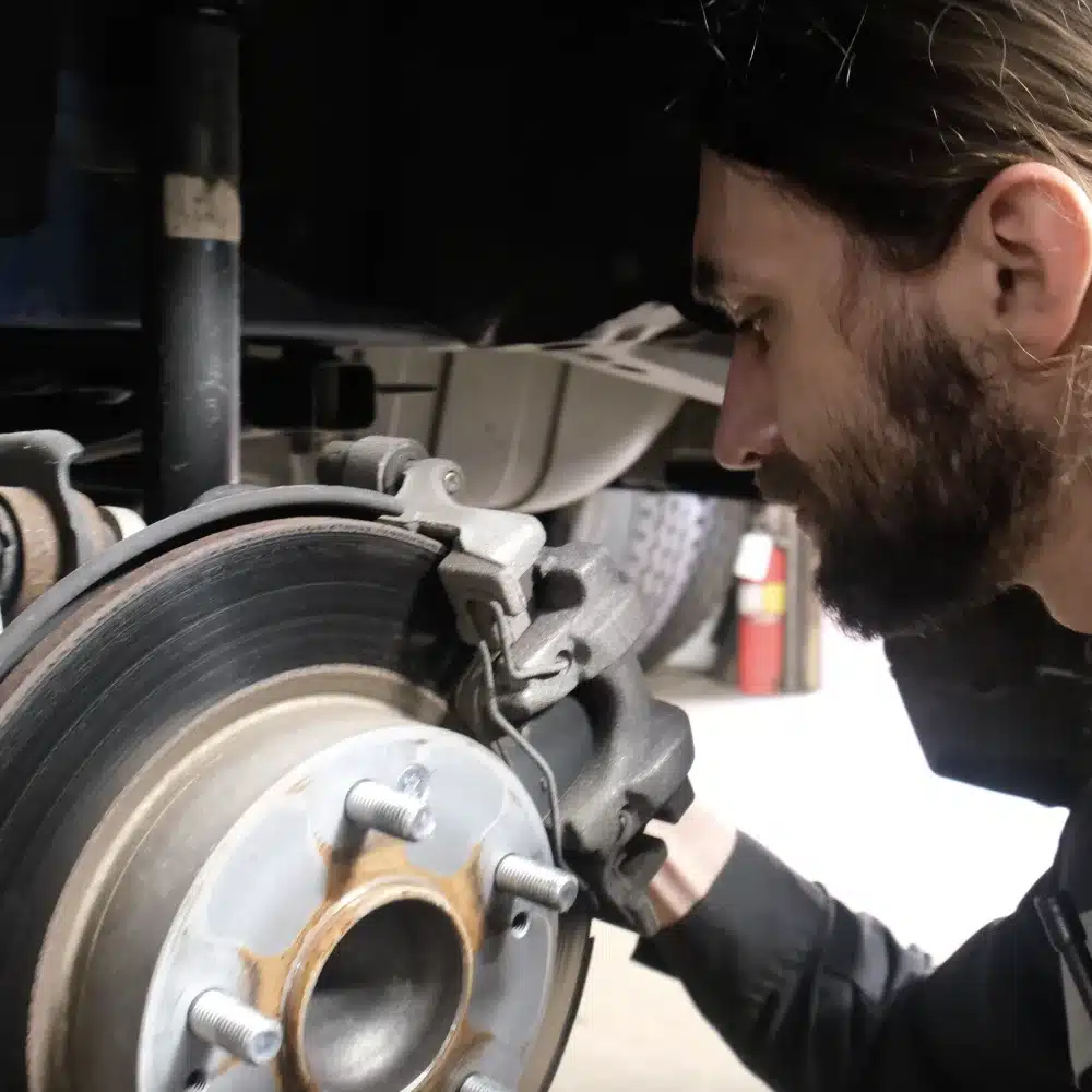 Brake Repair & Service in Blowing Rock, NC. Image of our auto repair technician inspecting the brake pad and brake rotor of a car