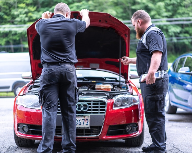 Audi Service in Blowing Rock, NC at L&N Performance. Image of L&N Performance Auto Repair founder Lucas Underwood and a technician conducting Audi service and maintenance under the open hood of an Audi car.