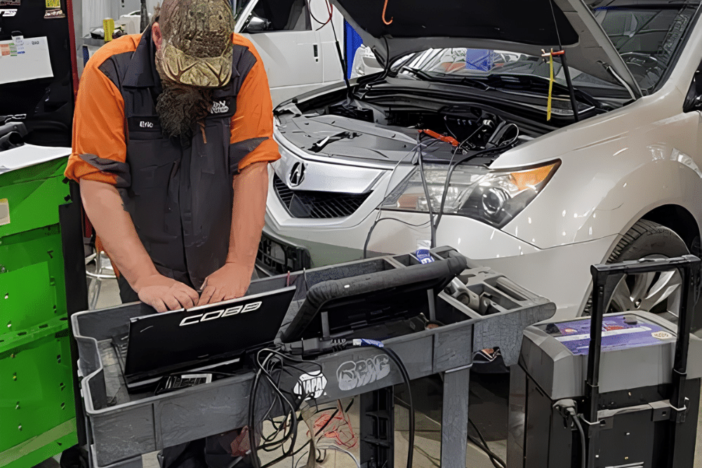 Digital Vehicle Inspection in Blowing Rock, NC At L&N Performance. Image of Mechanic using a diagnostic laptop during a vehicle inspection with an open hood