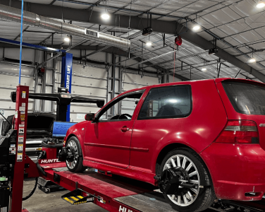 wheel alignment, auto repair in Blowing Rock, NC at L&N Performance Auto Repair. Red Volkswagen Golf R32 on a Hunter alignment rack inside a well-lit auto repair shop, with another vehicle being serviced in the background.